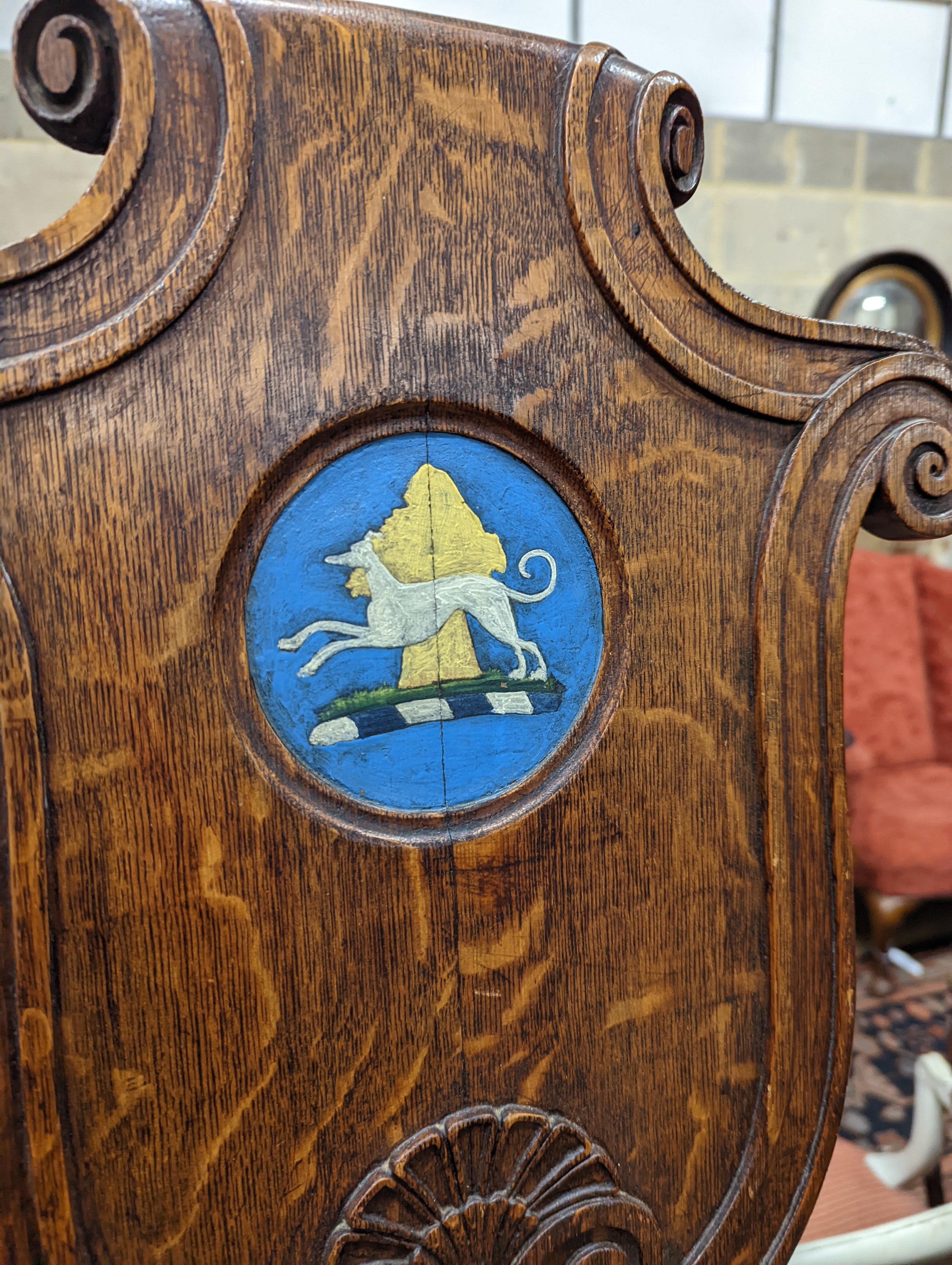 A pair of Victorian oak hall chairs with painted armorials, width 43cm, depth 39cm, height 94cm